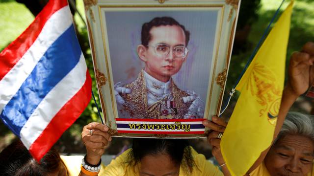 Well-wishers hold a picture of Thailand's King Bhumibol Adulyadej at the Siriraj hospital where he is residing, in Bangkok