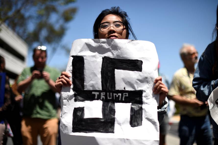 Carla Espinosa holds a protest sign against presidential candidate Donald Trump outside the California Republican Party convention in Burlingame