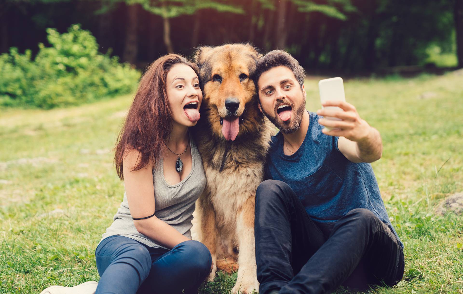 Dog owners taking selfie with dog in the city park