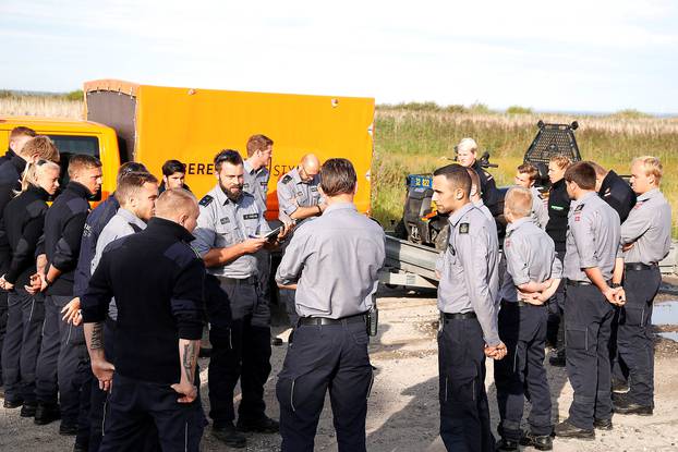 Members of The Danish Emergency Management Agency (DEMA) (Danish: Beredskabsstyrelsen) prepare to assist police at Kalvebod Faelled in Copenhagen