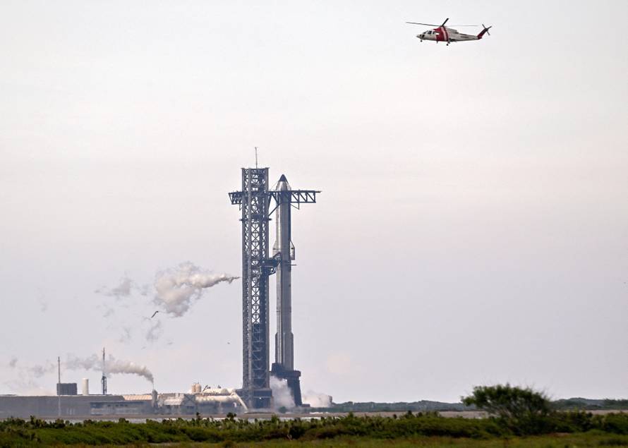 A SpaceX Super Heavy booster carrying the Starship spacecraft vents before the launch is scrubbed