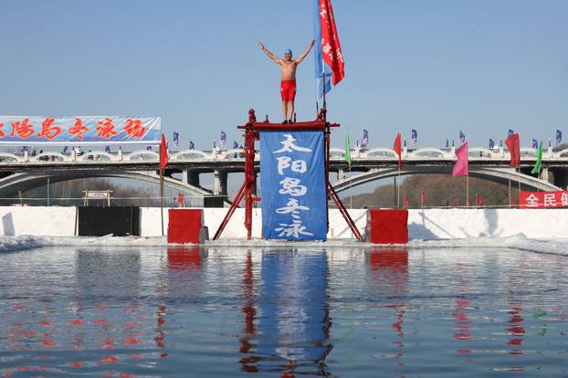 Locals participate in winter swimming events during the annual ice and snow sculpture festival, in Harbin 