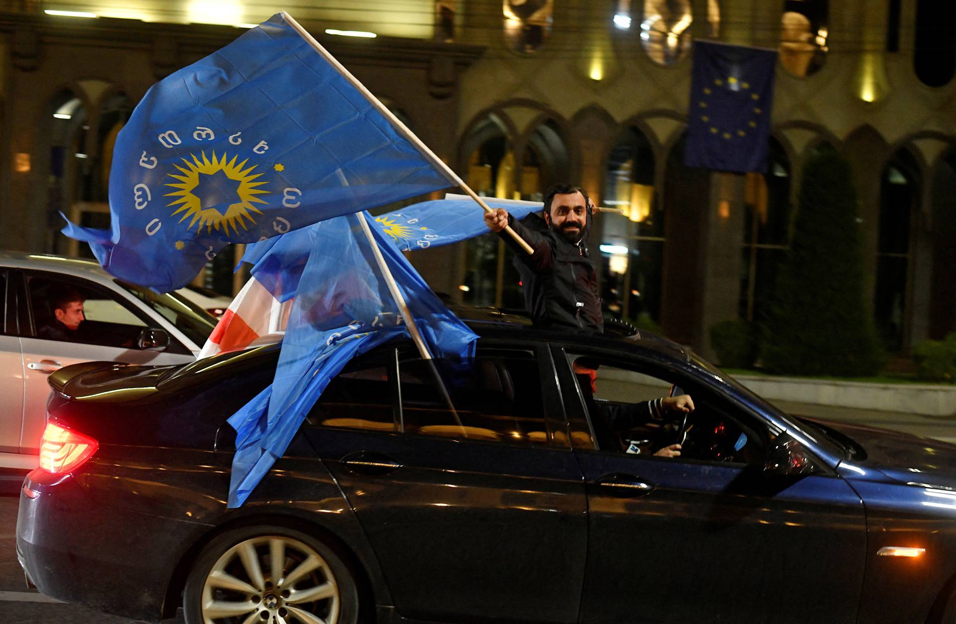 Supporters of the Georgian Dream party celebrate after the announcement of exit poll results in Tbilisi