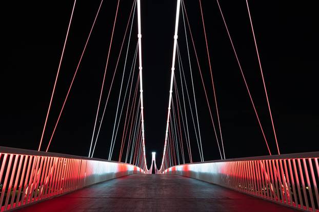 Osijek: Pješački most osvijetljen crveno bijelom  bojom povodom Dana sjećanja na žrtvu Vukovara i Škabrnje