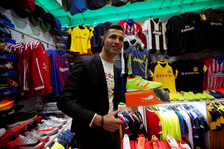 Biwar Abdullah, 25, an Iraqi Kurdish local footballer, who looks like the football player Cristiano Ronaldo, pose for a pictures at a sportswear shop in the district of Soran, northeast of Erbil