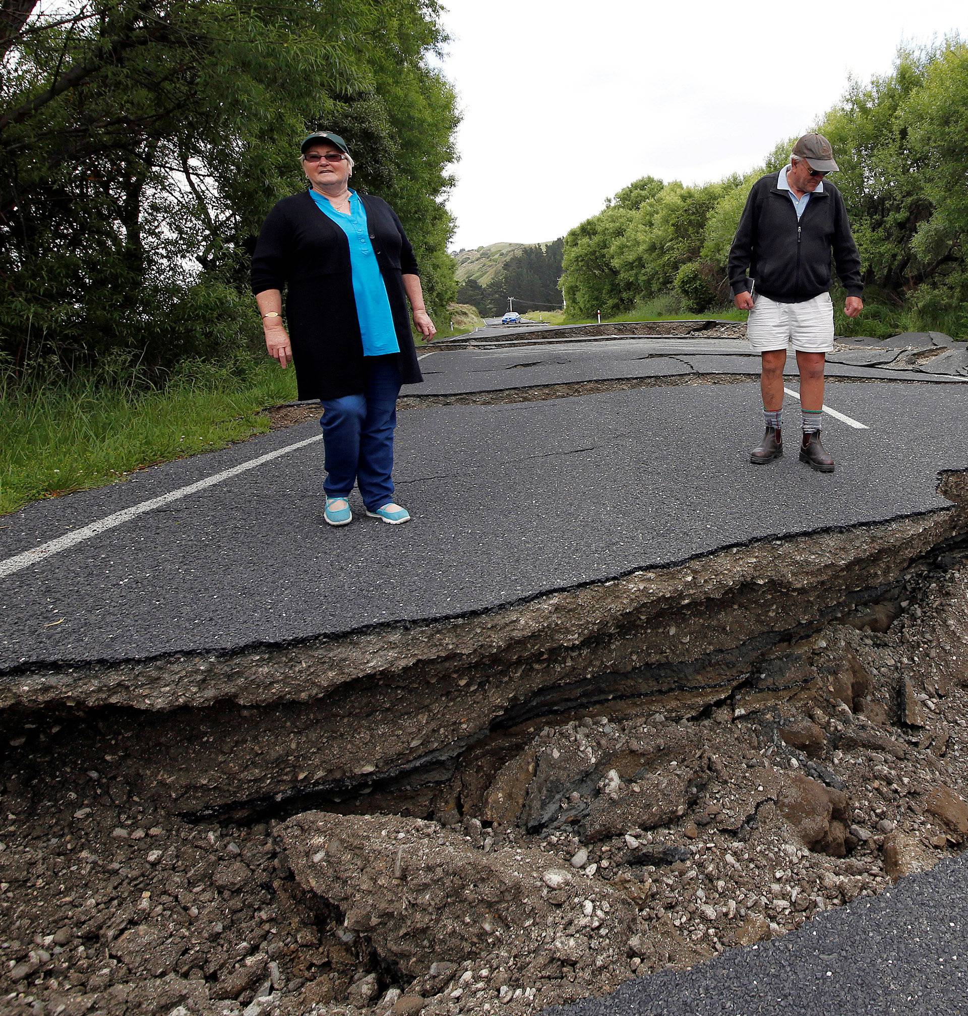Local residents Chris and Viv Young look at damage caused by an earthquake along State Highway One near the town of Ward, south of Blenheim on New Zealand's South Island