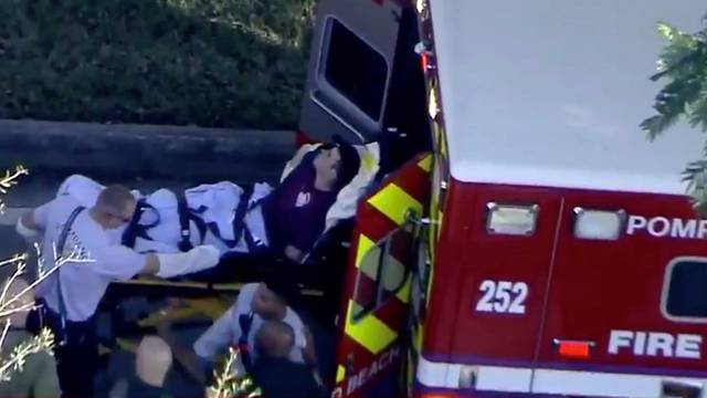 A man who was placed in handcuffs by police is loaded into a paramedic vehicle after a shooting incident at Marjory Stoneman Douglas High School in Parkland