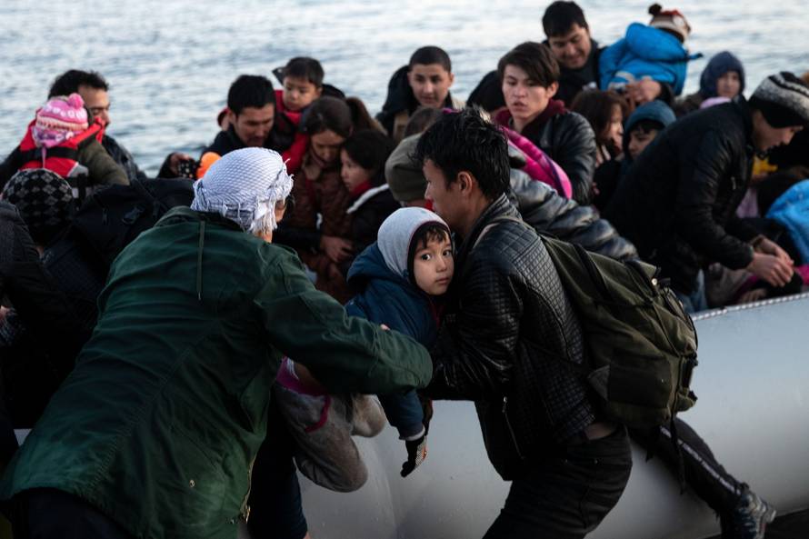 Migrants from Afghanistan arrive on a dinghy on a beach near the village of Skala Sikamias, after crossing part of the Aegean Sea from Turkey to the island of Lesbos