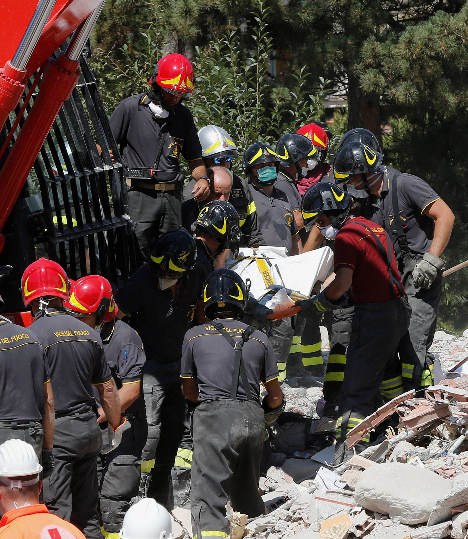 A body is carried away by rescuers following an earthquake in Amatrice