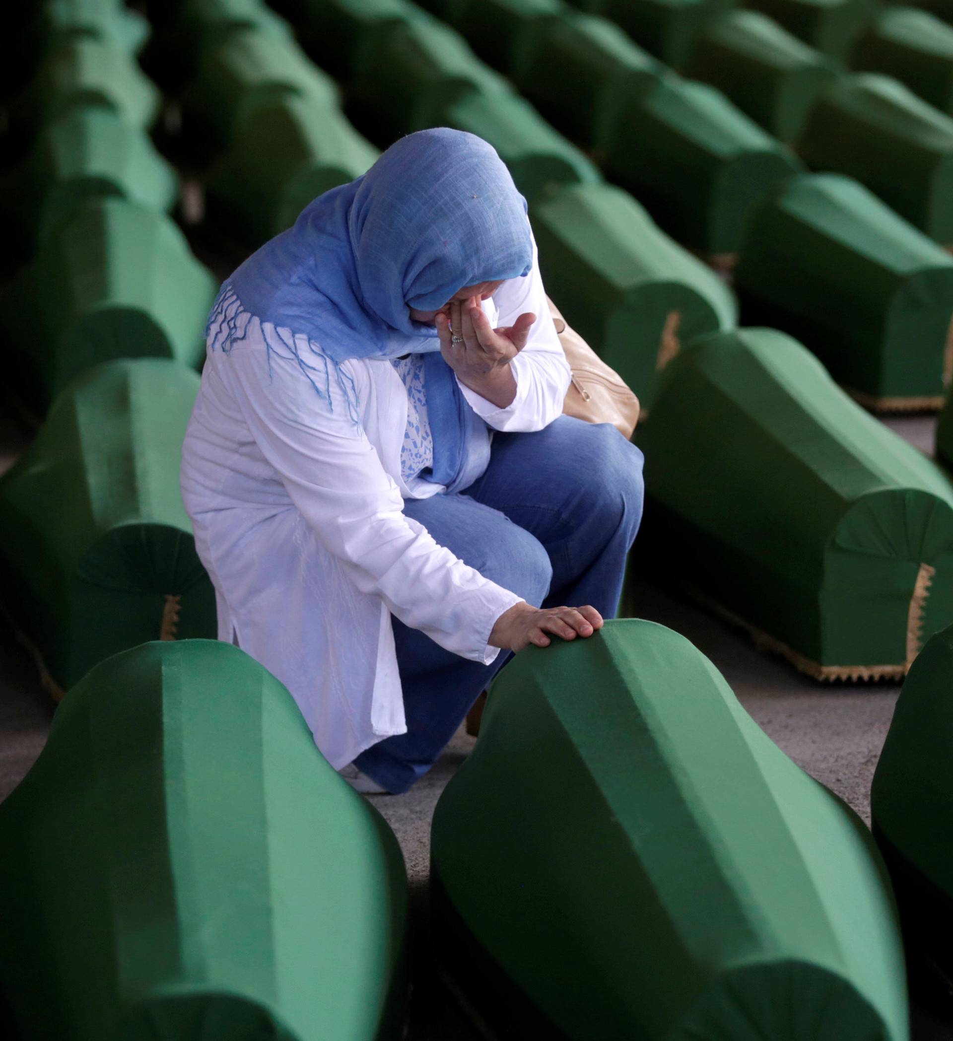 A Muslim woman cries near the coffin of her relatives, who are newly identified victims of the 1995 Srebrenica massacre and lined up for a joint burial in Potocari near Srebrenica, Bosnia and Herzegovina
