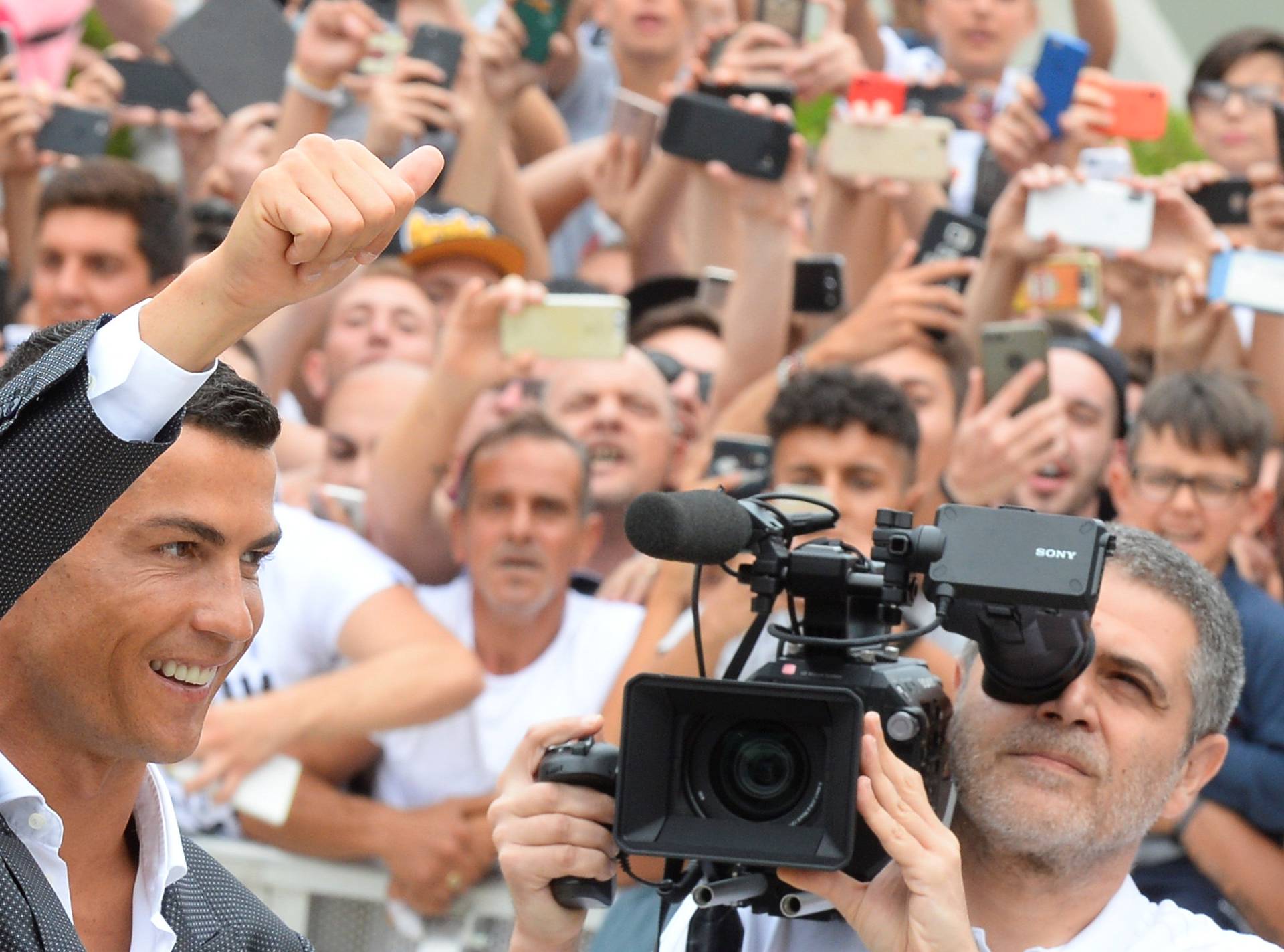 Cristiano Ronaldo gestures as he arrives at the Juventus' medical center in Turin