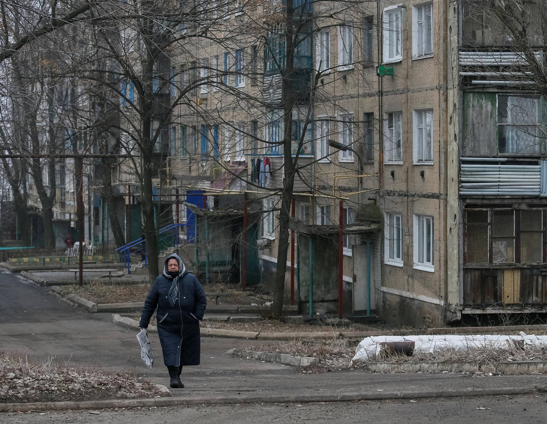 Local resident walks along a street near the front line near the city of Novoluhanske