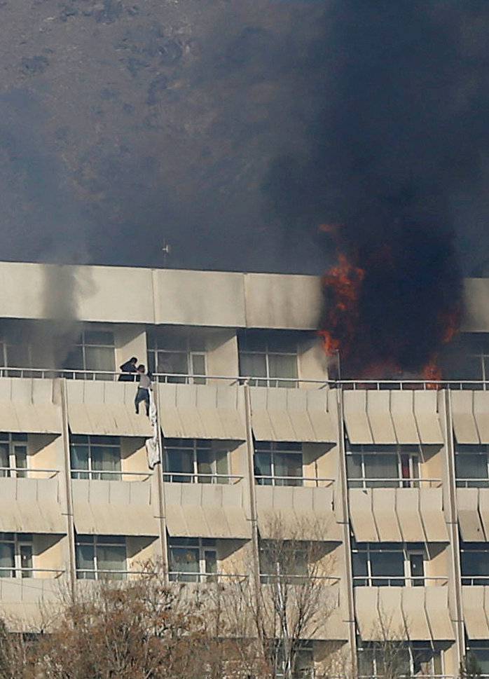 A man tries to escape from a balcony at Kabul's Intercontinental Hotel during an attack by gunmen in Kabul