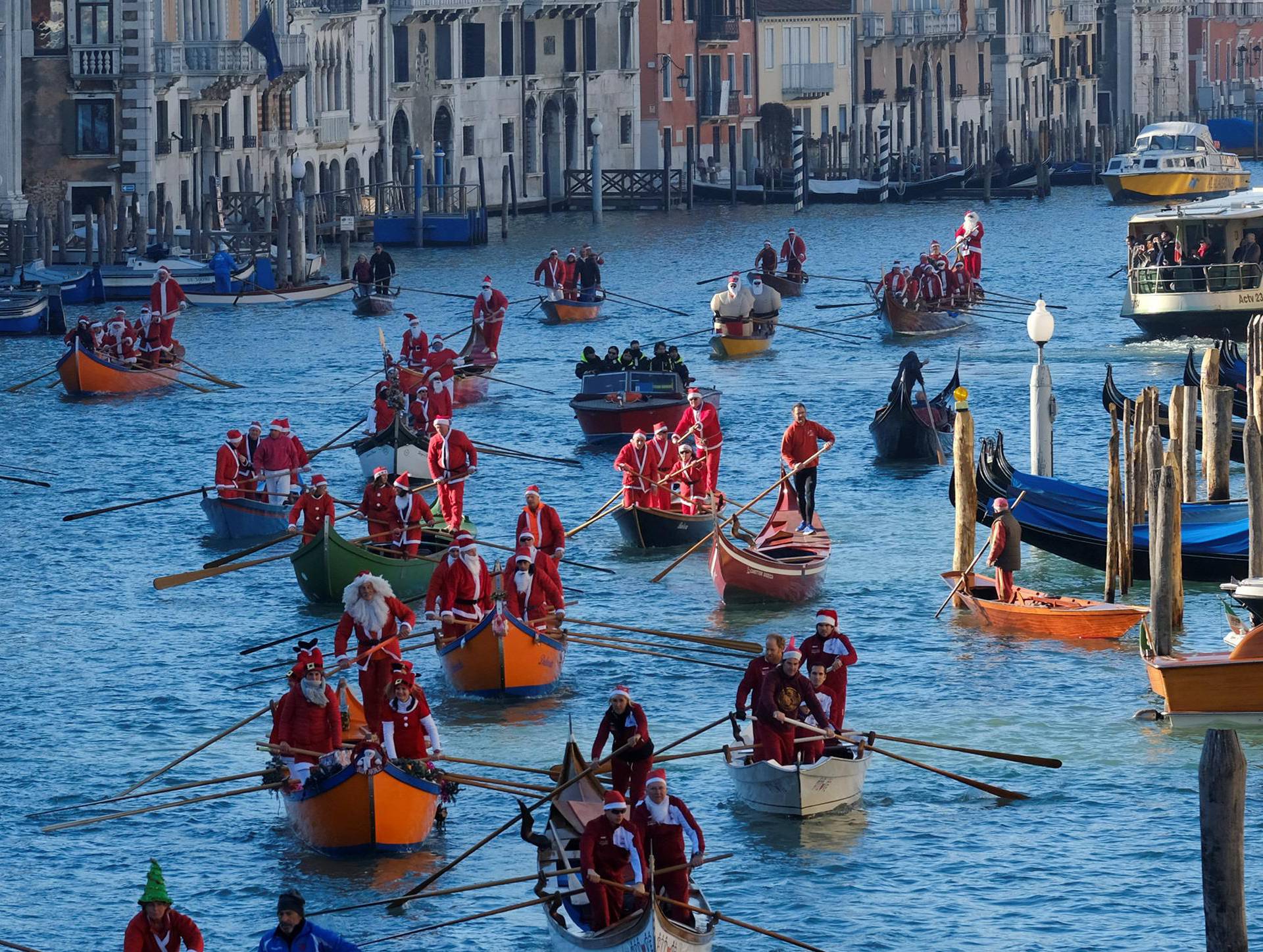 People dressed as Santa Claus row during a Christmas regatta in Venice