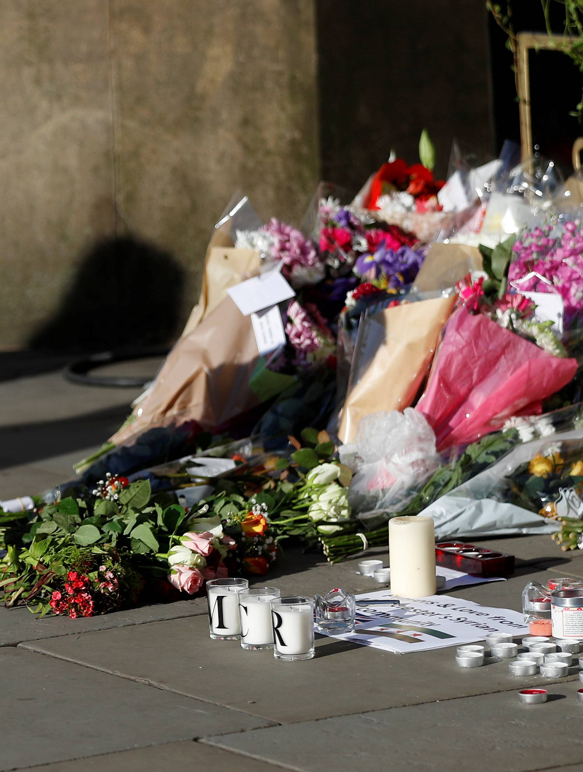 A girl leaves flowers for the victims of an attack on concert goers at Manchester Arena, in central Manchester