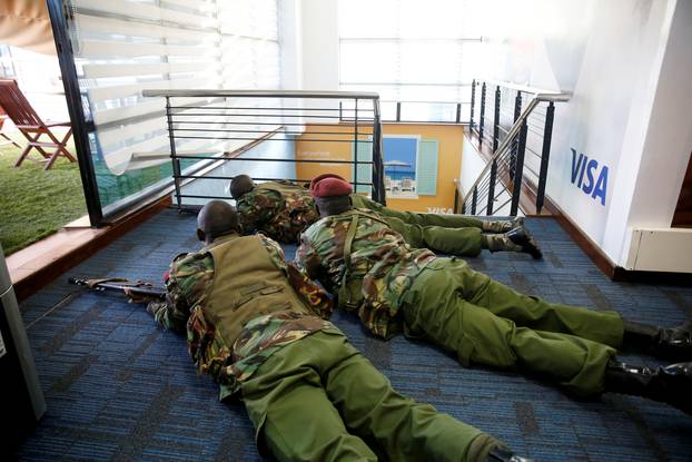 Members of security forces secure a building at the scene where explosions and gunshots were heard at the Dusit hotel compound