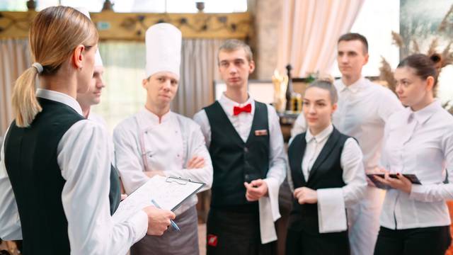 Restaurant,Manager,And,His,Staff,In,Kitchen.,Interacting,To,Head
