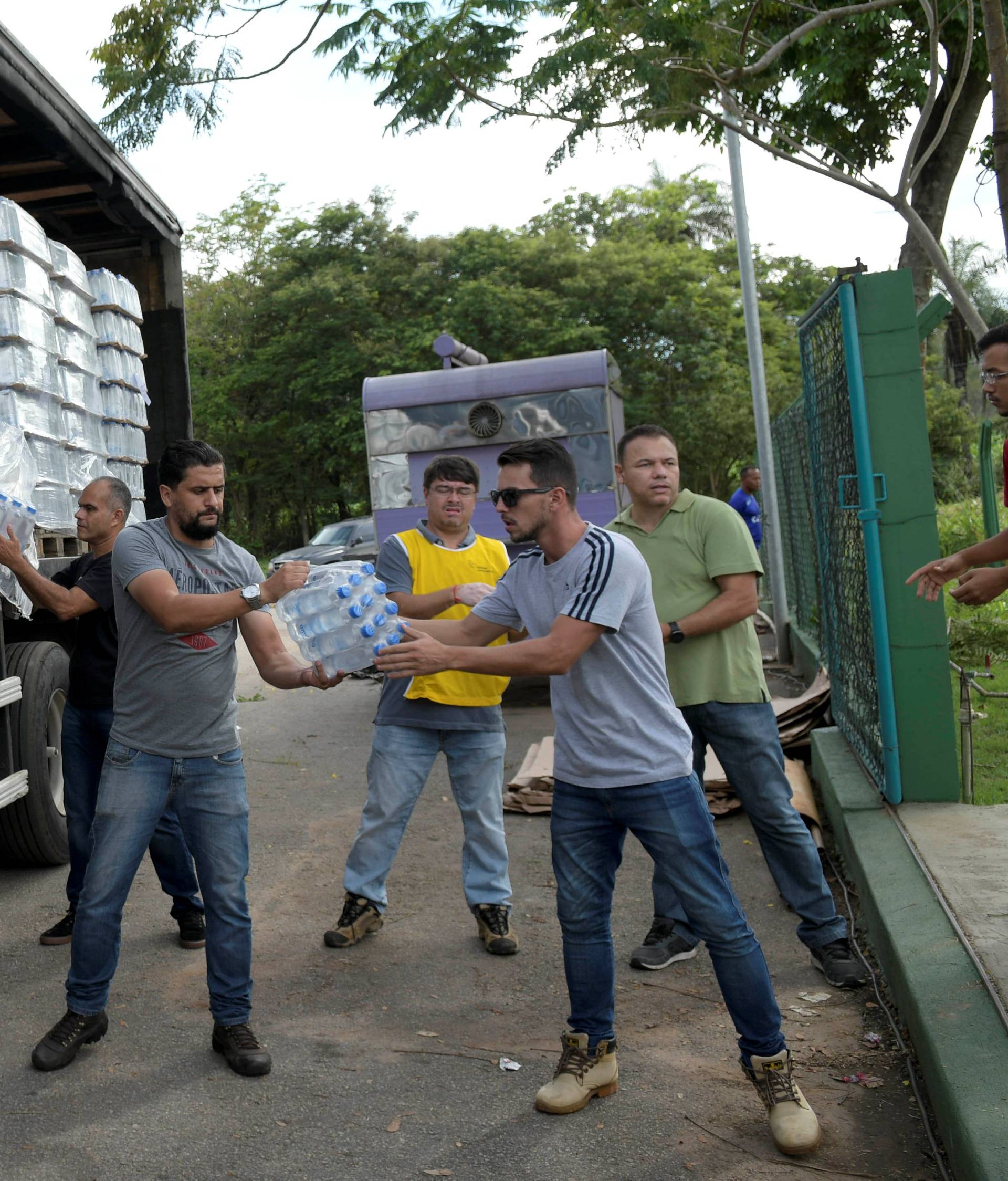 Volunteers pass bottles of water for people affected of the aftermath from a failed iron ore tailings dam owned by Brazilian miner Vale SA that burst, in Brumadinho