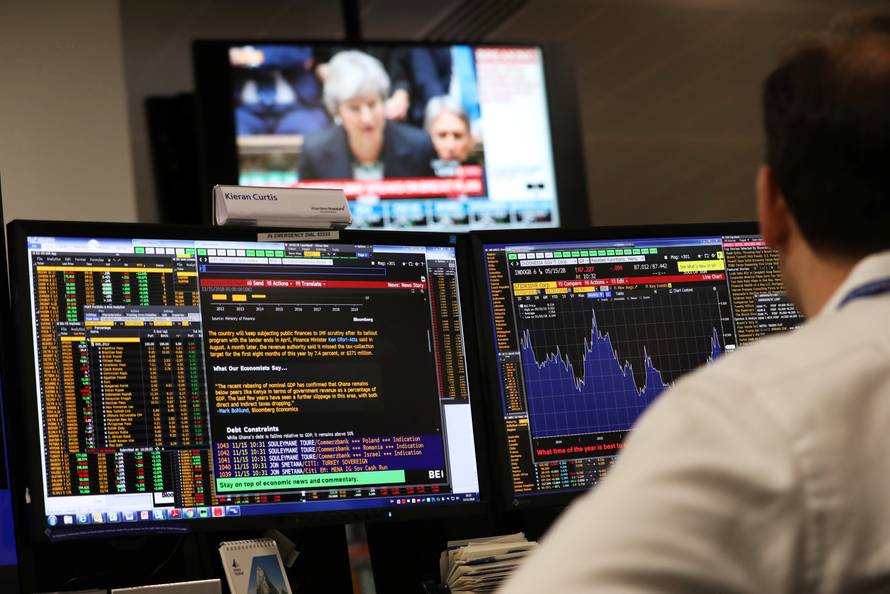 An investment manager, in the office of Aberdeen Standard Investments, watches Britain's Prime Minister, Theresa May, deliver a statement to the House of Commons, in London