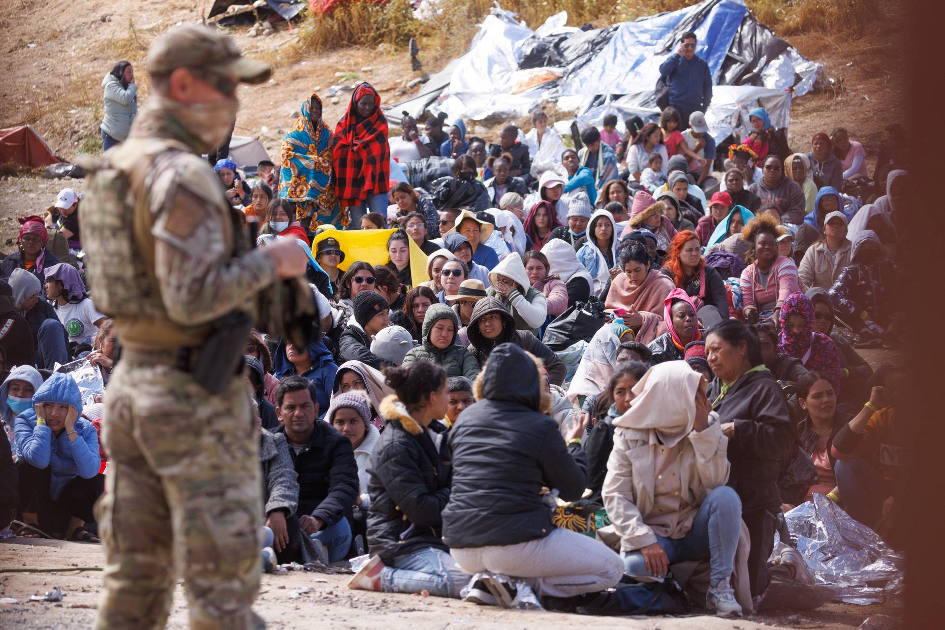 Migrants gather along the U.S. Mexico border near San Diego before the lifting of Tile 42