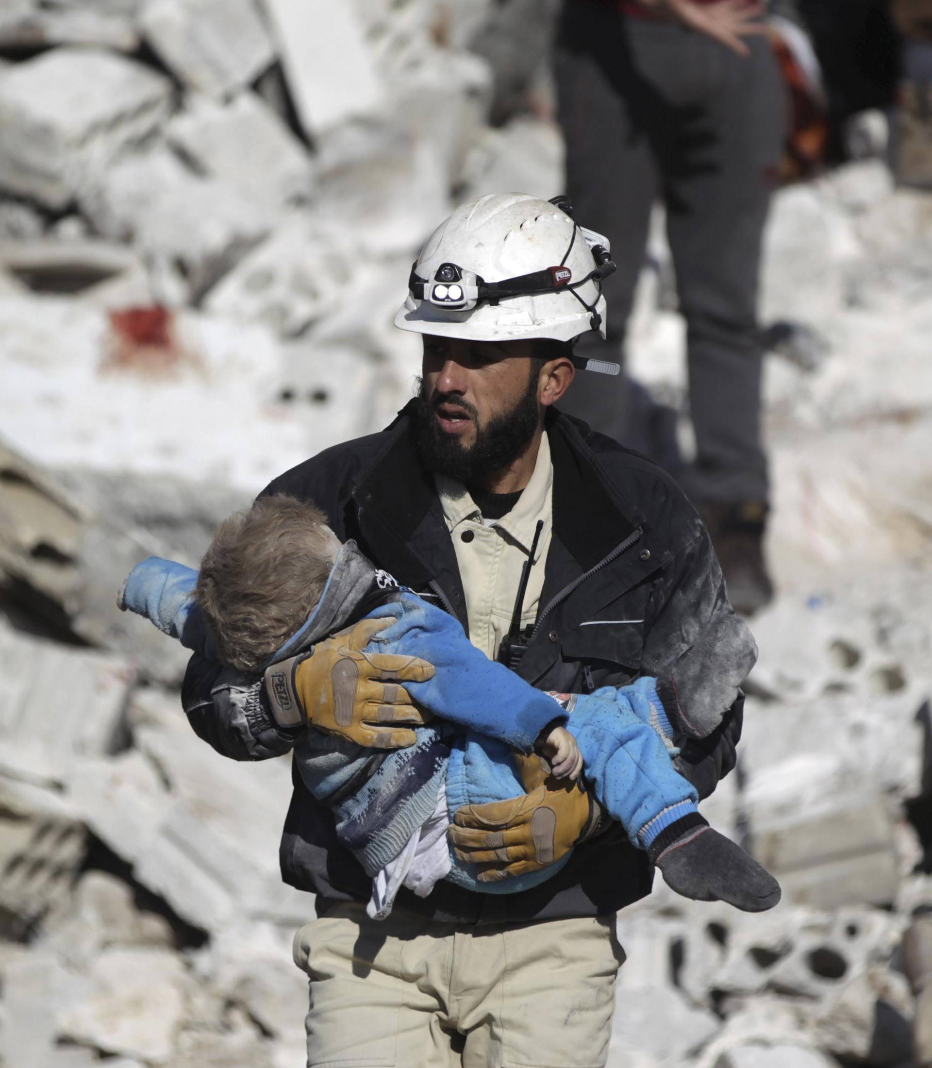 A civil defence member carries a dead child in a site hit by what activists said were airstrikes carried out by the Russian air force in the rebel-controlled area of Maaret al-Numan town in Idlib province, Syria