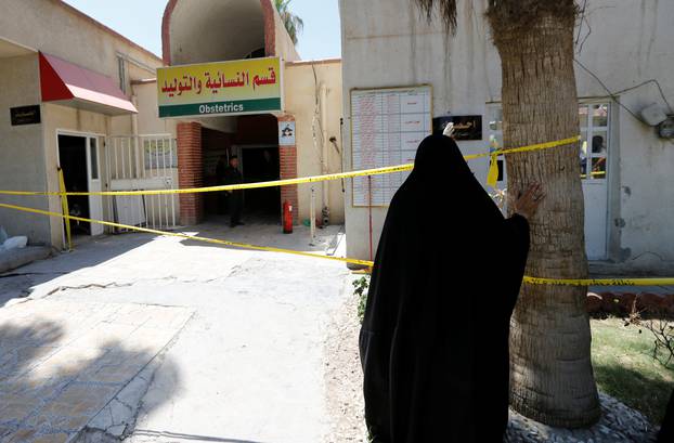 An Iraqi woman stands in front of a maternity ward after a fire broke out at Yarmouk hospital in Baghdad