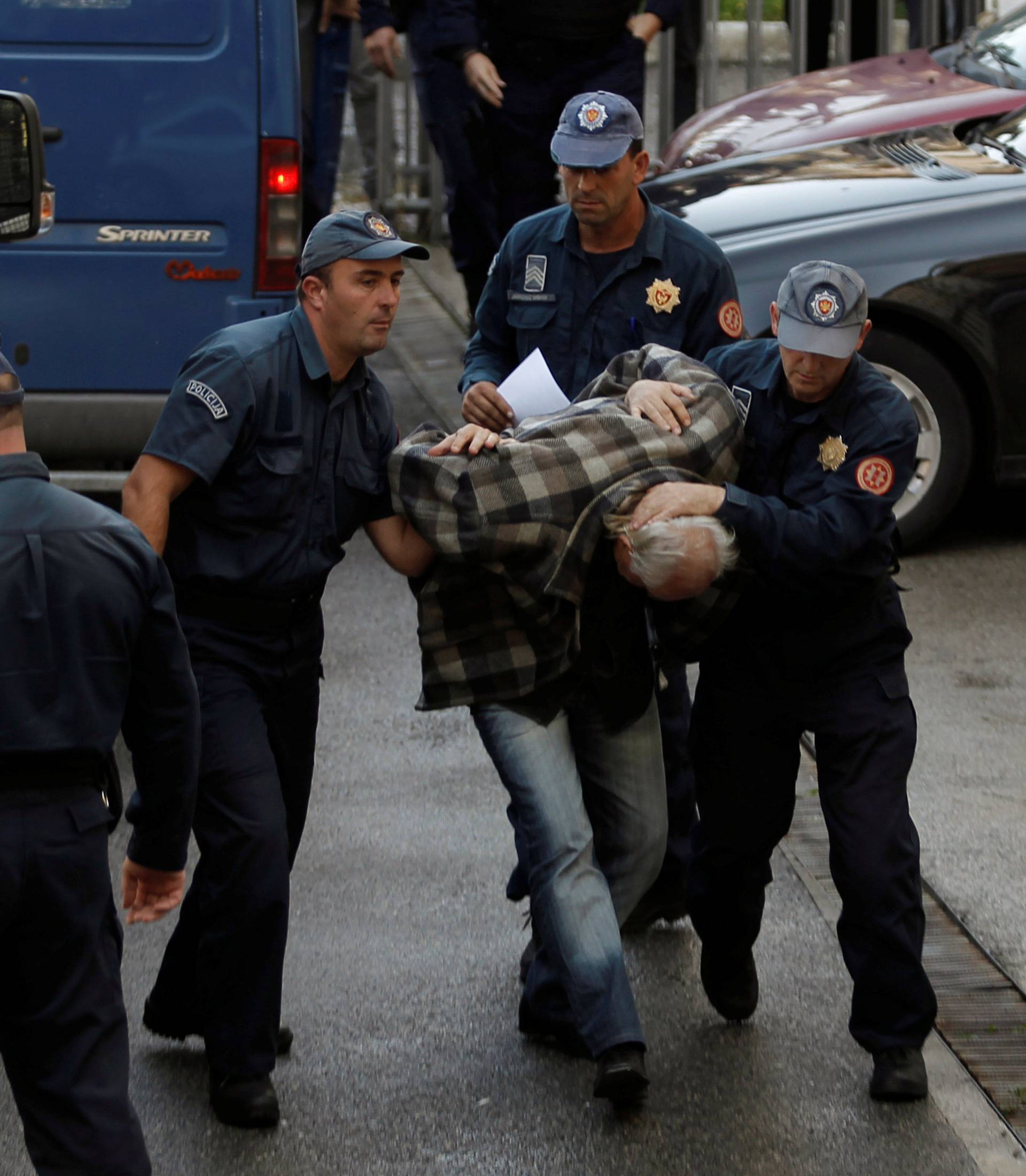 Montenegrin police escort men to a court session with the state attorney in Podgorica