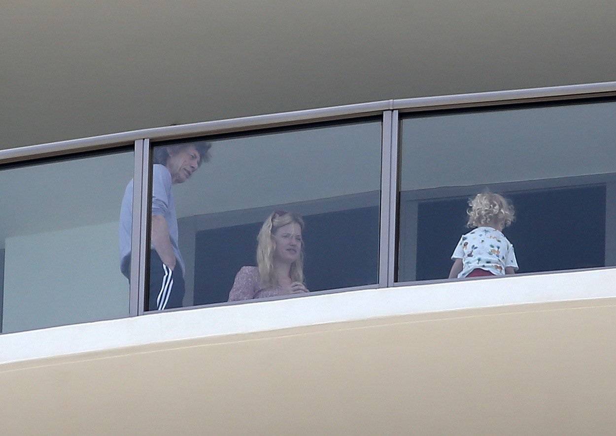 EXCLUSIVE: Mick Jagger is seen playing with his son and being comforted by his wife  Melanie Hamrick on their balcony in Miami