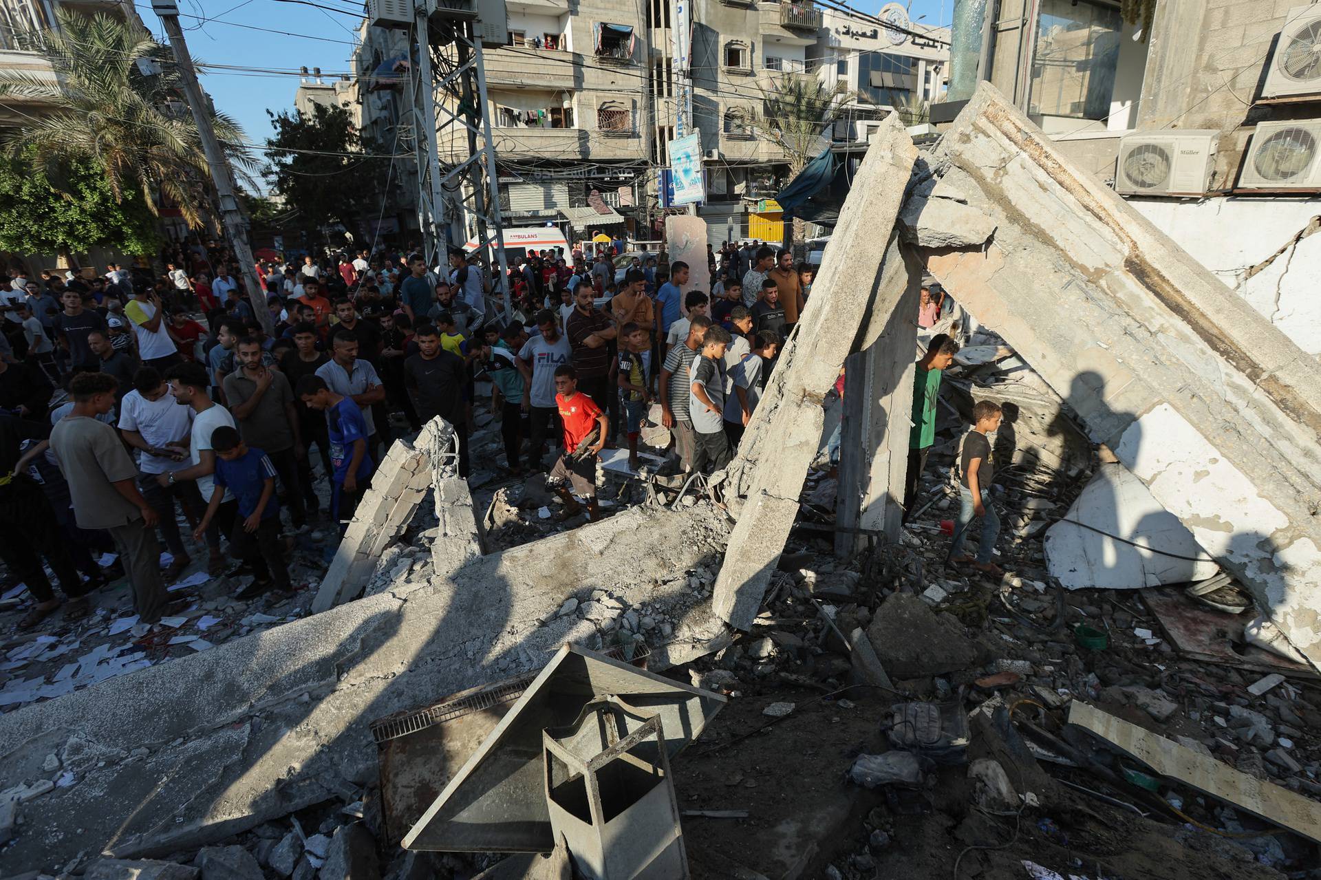 Palestinians react, after an Israeli air strike on a UN school sheltering displaced people, amid the Israel-Hamas conflict, in Nusairat