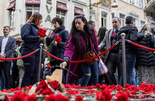People lay flowers to pay tribute to the victims of a Sunday's blast that took place on Istiklal Avenue in Istanbul