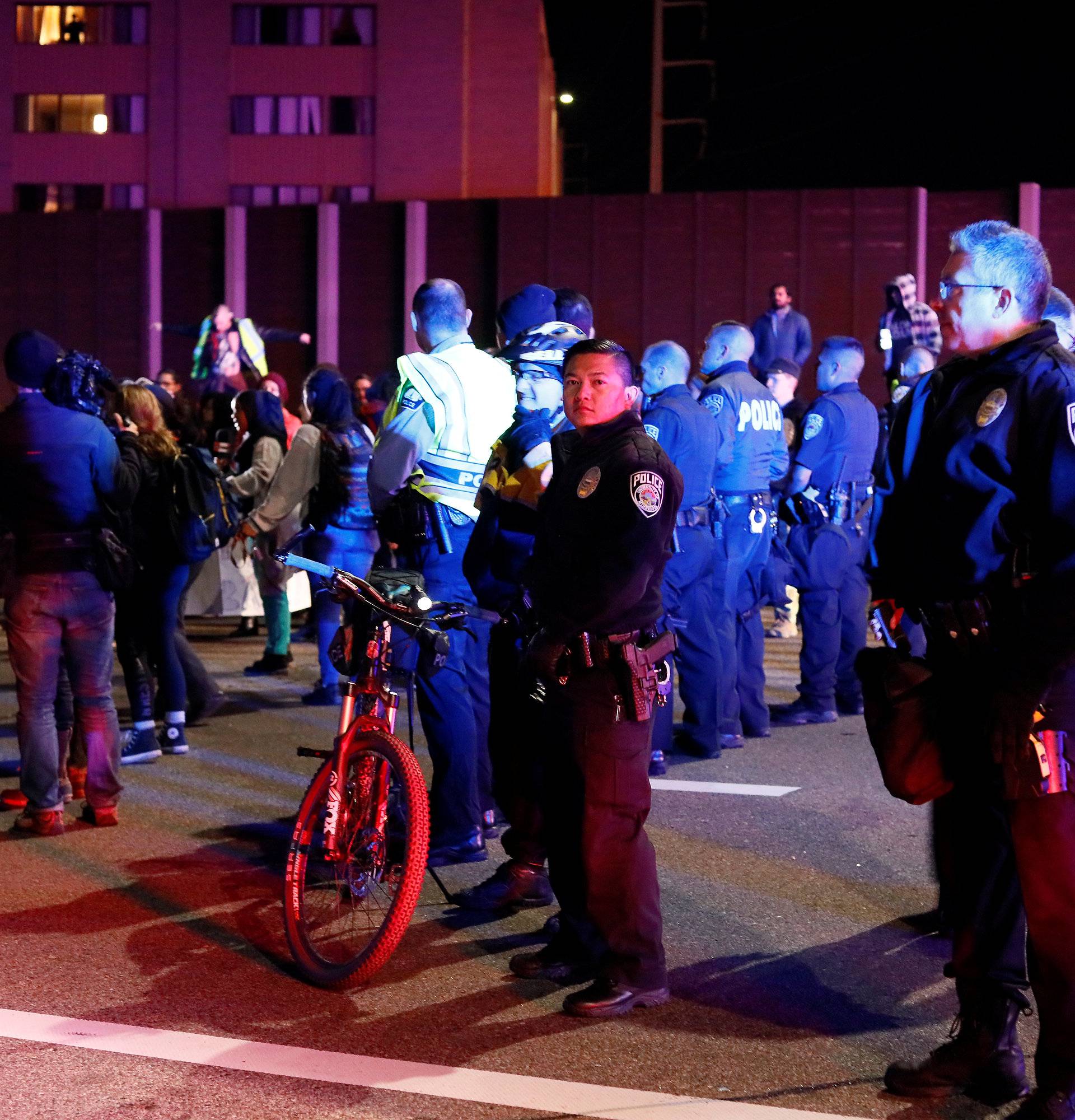 Police keep watch as demonstrators protest against President-elect Donald Trump in Minneapolis