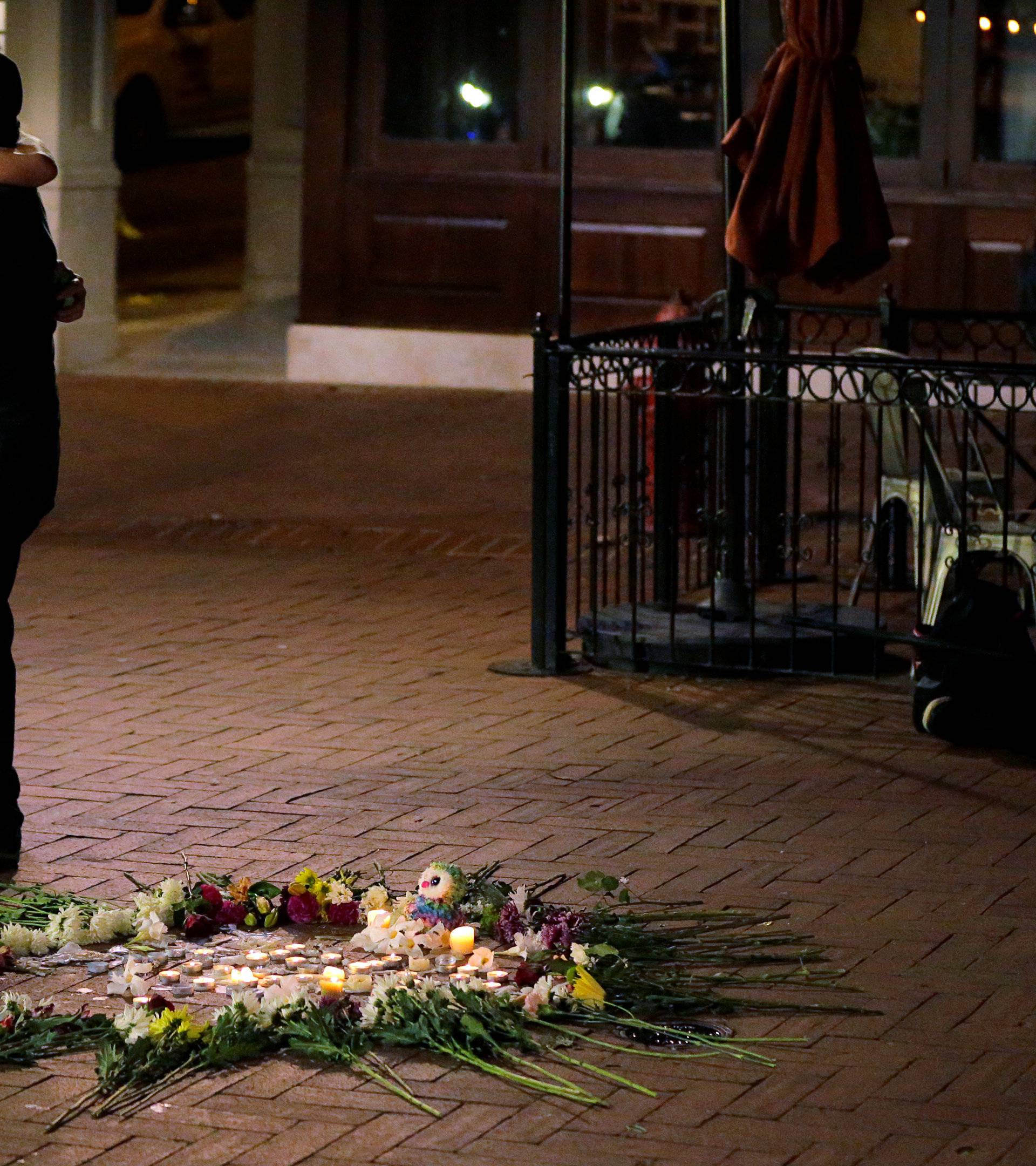 Passerby comforts a man at late night vigil for victims of the car attack on counter protesters at the "Unite the Right" rally in Charlottesville