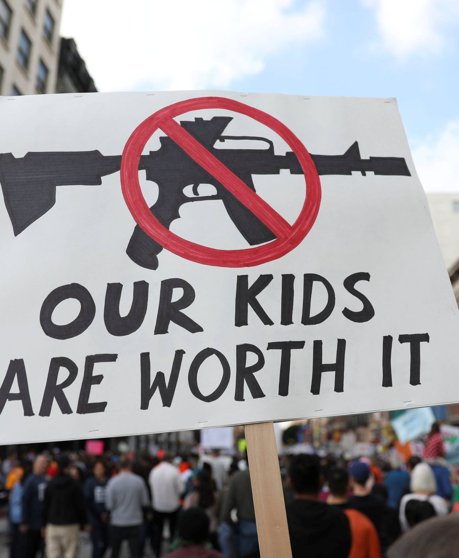People walk with signs against assault rifles during "March for Our Lives", an organized demonstration to end gun violence, in downtown Los Angeles