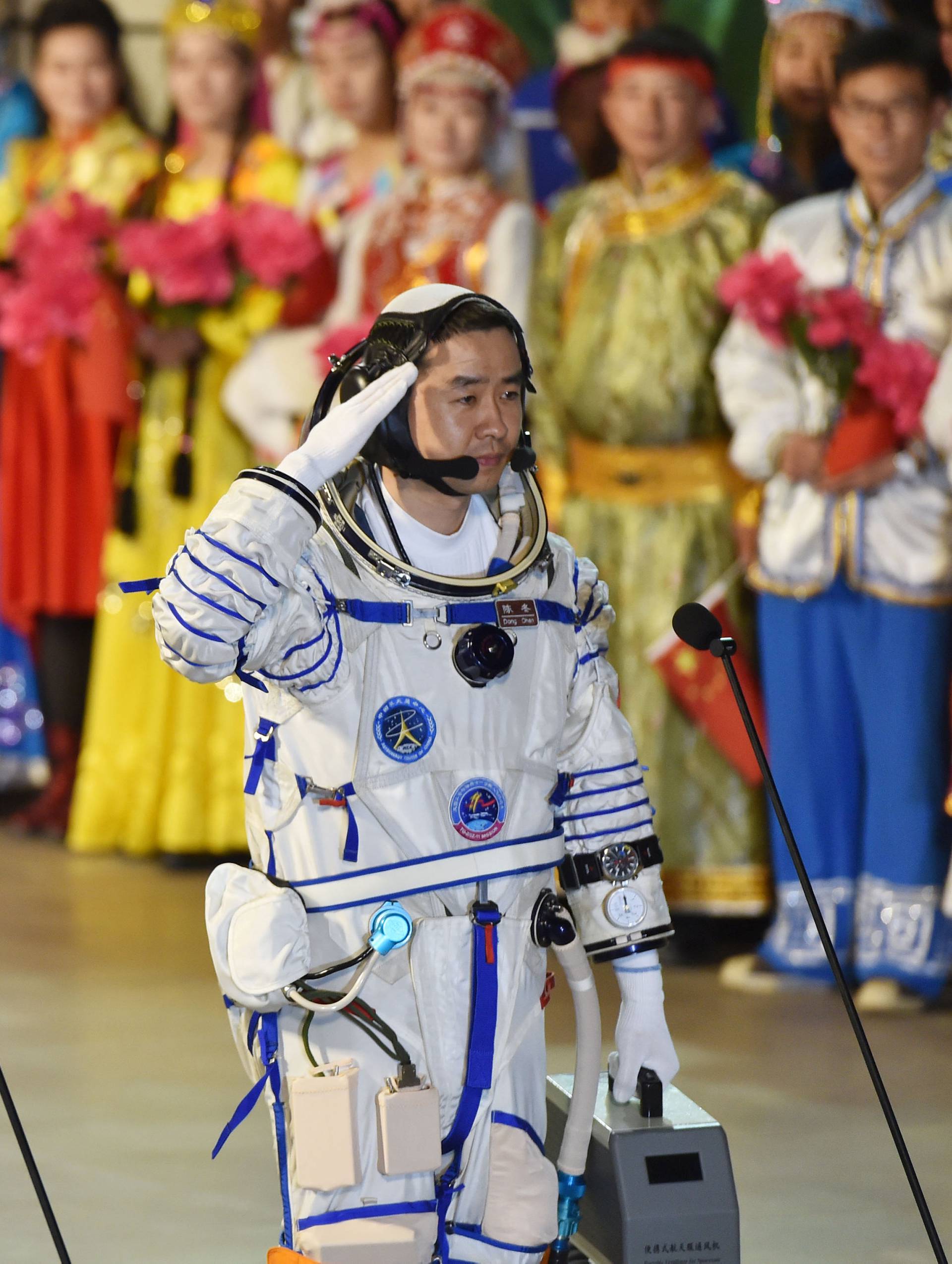Chinese astronauts Jing Haipeng, Chen Dong salute before the launch of the Shenzhou-11 manned spacecraft, in Jiuquan