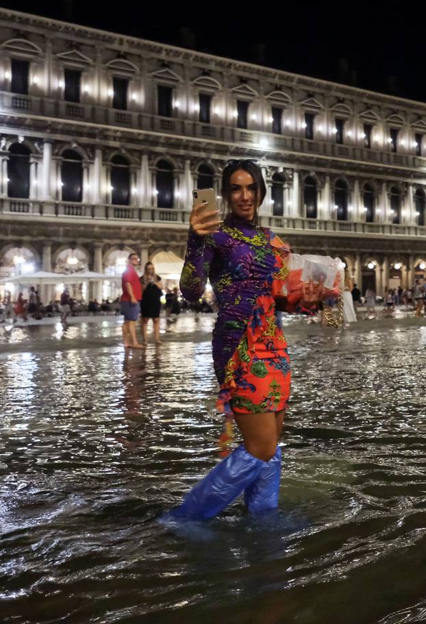 A woman walks in a flooded St. Mark
