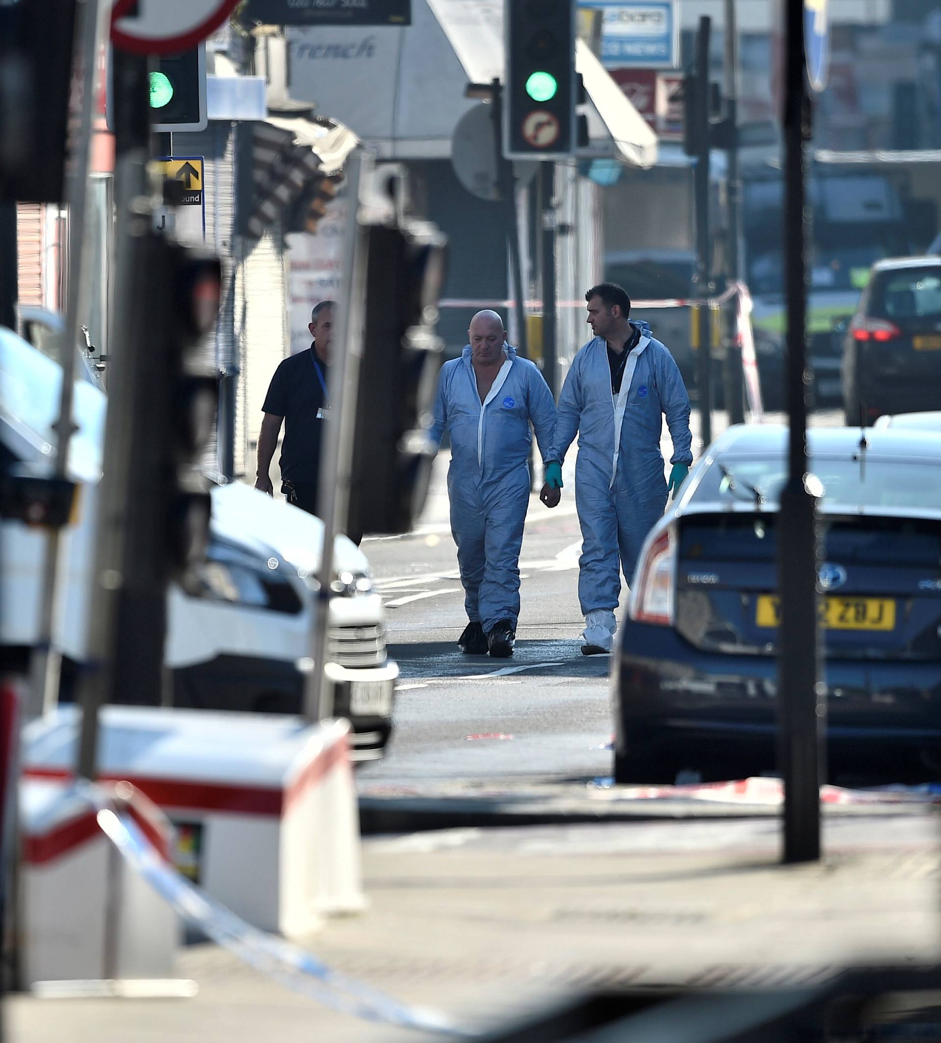 Police forensic officers walk down a road close to where a vehicle collided with pedestrians in the Finsbury Park neighbourhood of North London