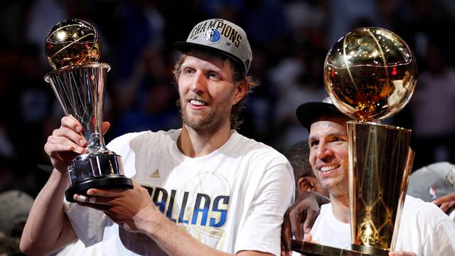 File Photo: Mavericks' Nowitzki holds the Bill Russell NBA Finals MVP trophy as Kidd holds the Larry O'Brien Championship Trophy after their team defeated the Heat to win the NBA Finals basketball series in Miami
