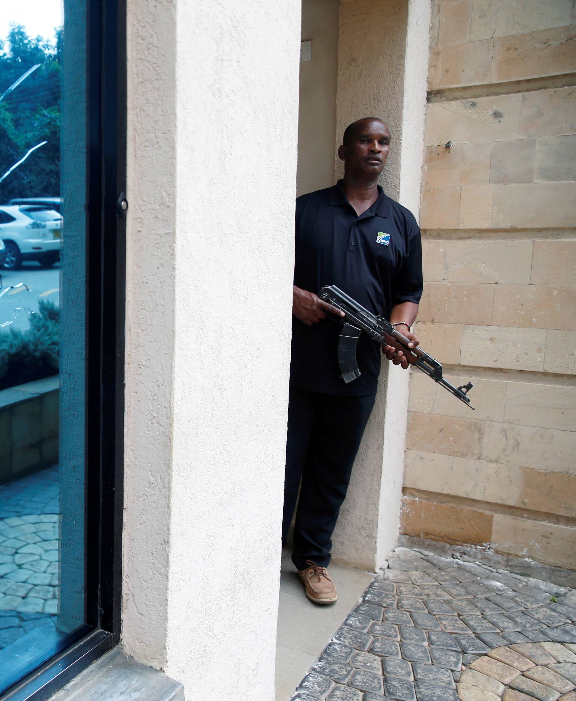 A policeman takes position at the scene where explosions and gunshots were heard at the Dusit hotel compound, in Nairobi