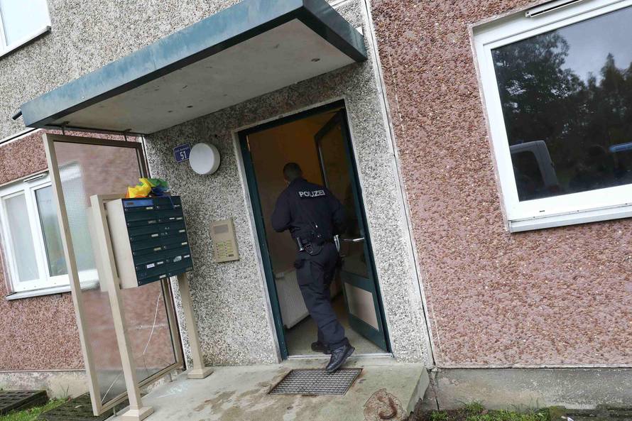 German police officer enters a building, that also serves as an accommodation facility for refugees, in Suhl