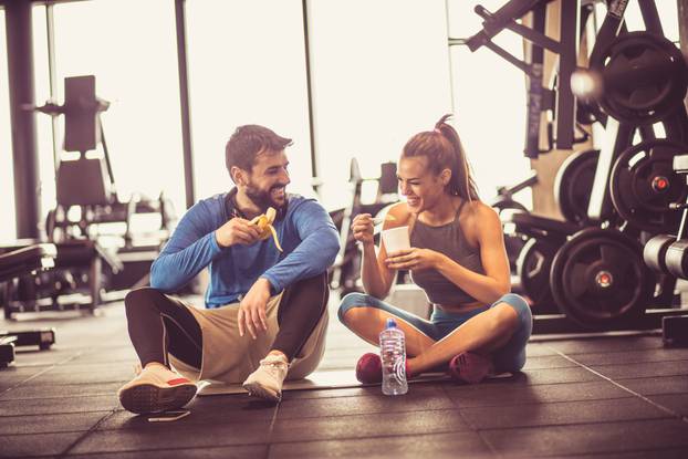 Young,Couple,At,Gym,Eating,Healthy,Food,After,Exercise.