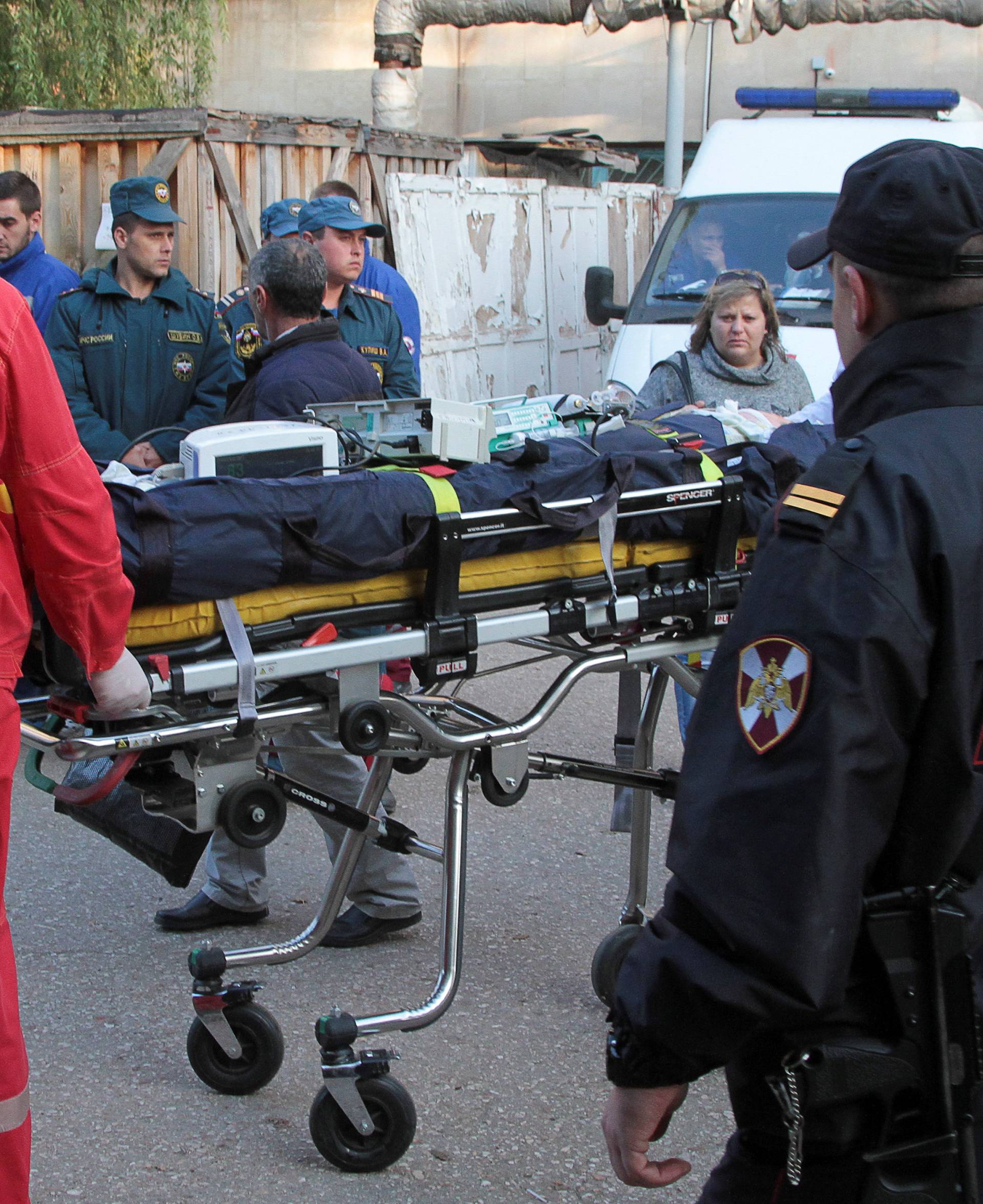 Medics transport injured people following an attack on a local college in Kerch