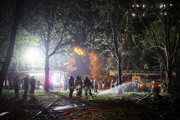 Firefighters work at the site of an apartment building hit by a Russian missile strike in Kyiv