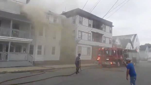 Still image from social media video footage by Boston Sparks shows a fire engine near a building emitting smoke after explosions in Lawrence, Massachusetts