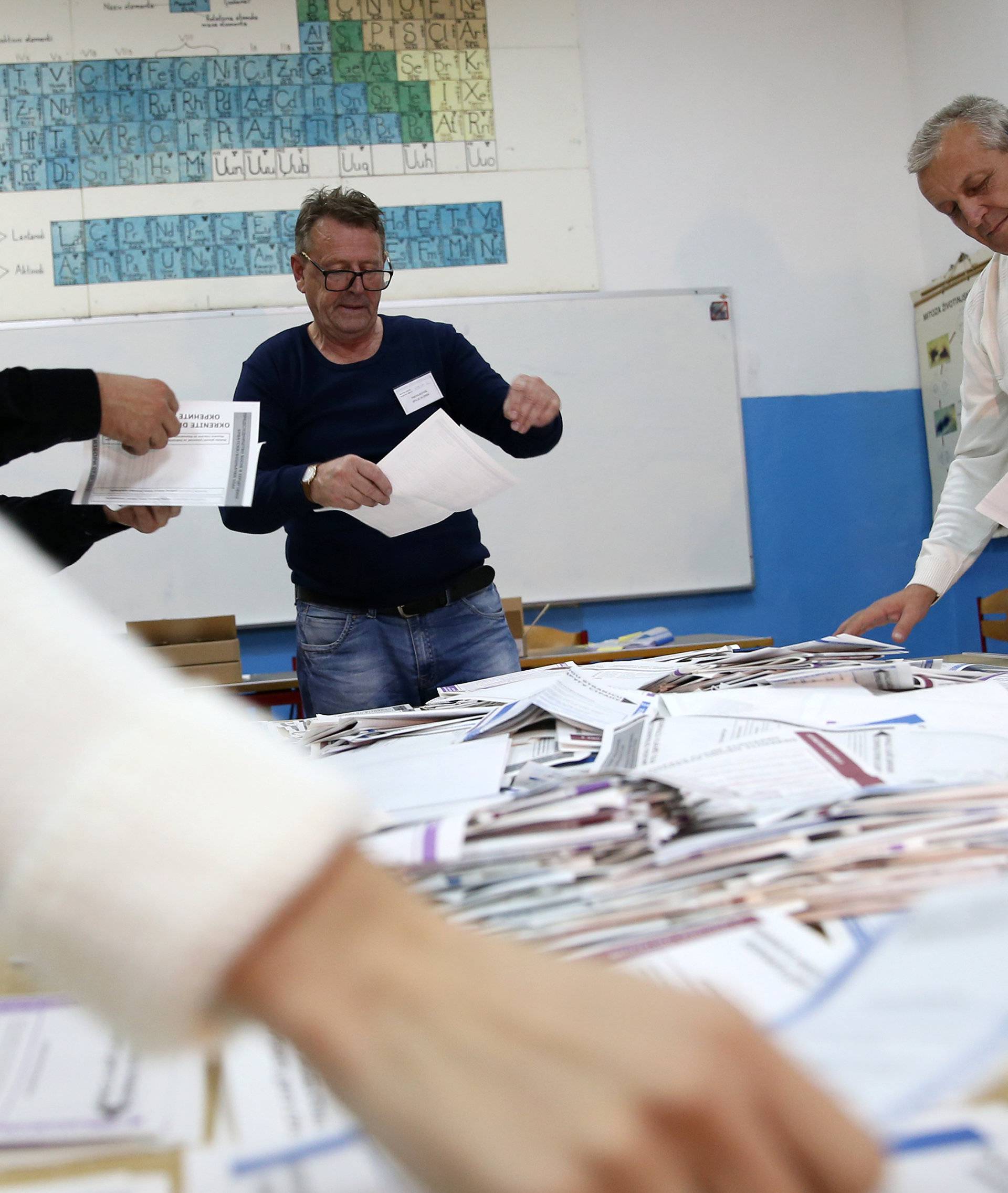 Election Commission officials count votes after presidential and parliamentary elections at a polling station in a school in Zenica