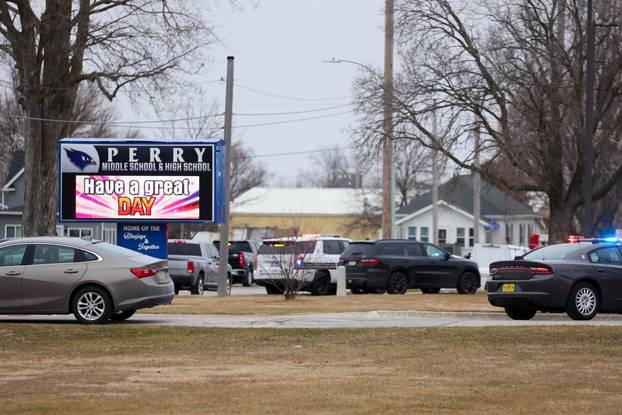 Law enforcement officers work at the scene of a shooting at Perry High School in Perry