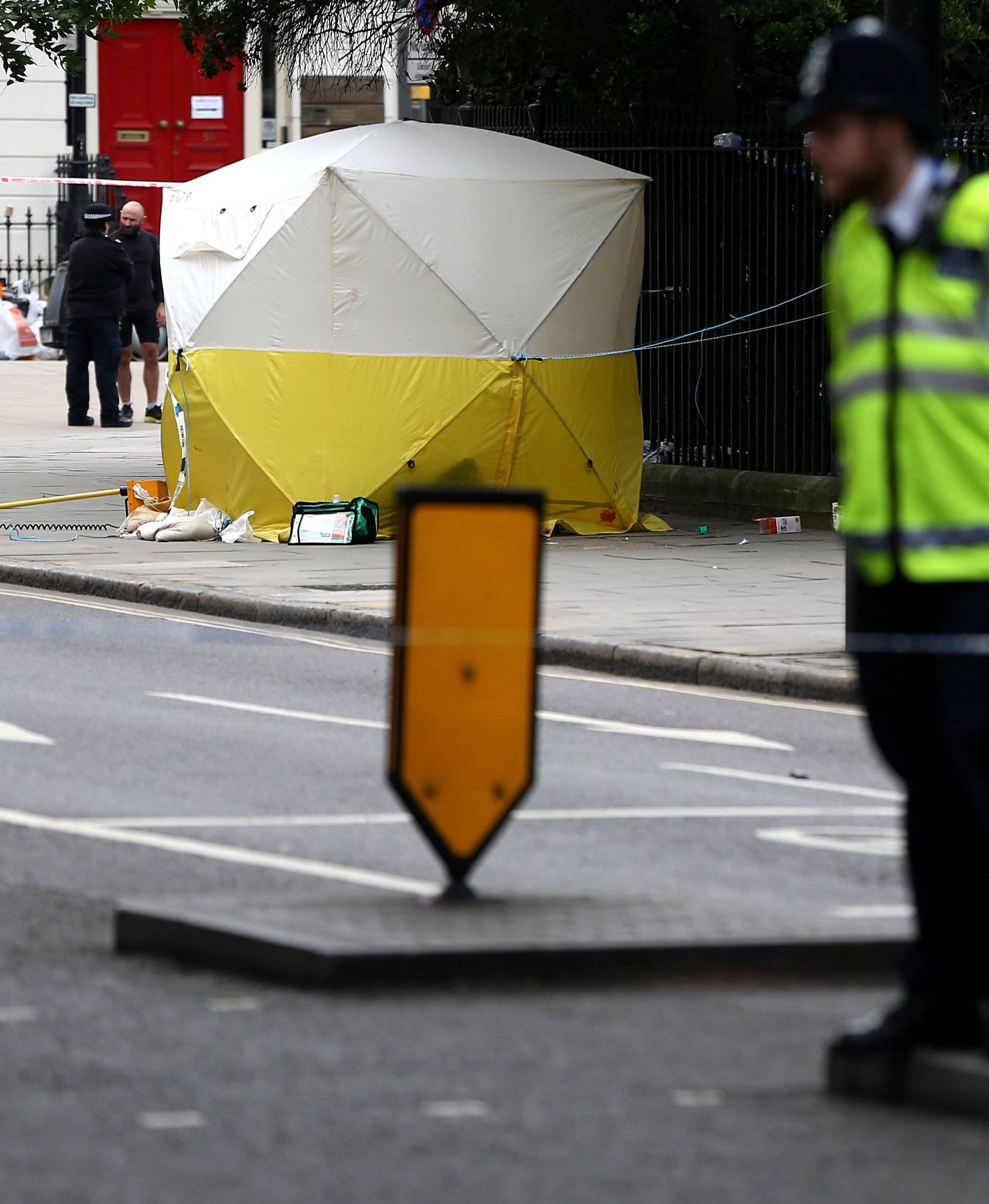 Police officers stand near a forensics tent after a knife attack in Russell Square in London