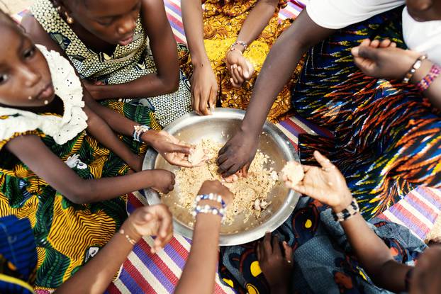 Group,Of,African,Girls,Sitting,On,A,Mat,,Dividing,Their