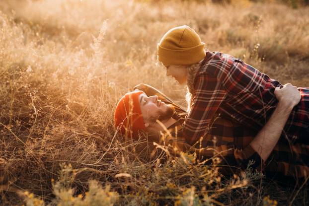 Cheerful guy and girl on a walk in bright knitted hats