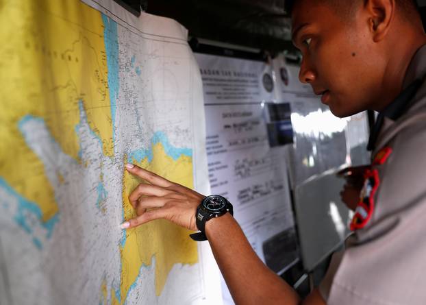 An Indonesian police officer studies a map in the search and rescue command center for the Lion Air flight JT610 crash, at Tanjung Priok port in Jakarta