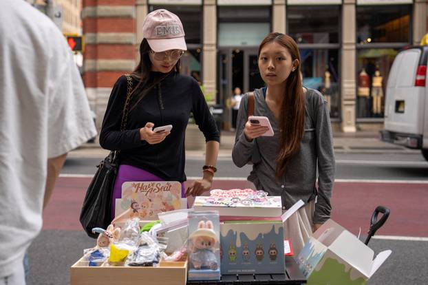 People sell counterfeit Labubu dolls on the sidewalk, in New York